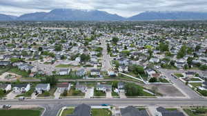 Aerial overview of property's location with a mountain backdrop and nearby suburban area