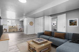Family room featuring a textured ceiling, LVP wood look floors, and baseboards
