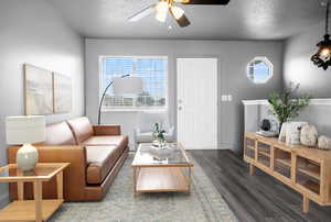 Living room with a ceiling fan, LVP, wood look finished floors, baseboards, and a textured ceiling
