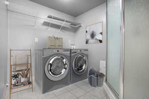 Laundry area with tile patterned floors