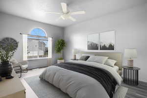 Master bedroom featuring LVP wood look floors, a textured ceiling, baseboards, and a ceiling fan