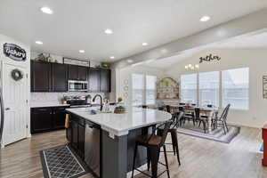 Kitchen with stainless steel appliances, a sink, huge island, decorative backsplash, and corner pantry.