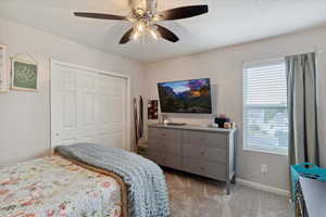Carpeted bedroom featuring window, a closet, and lots of space.