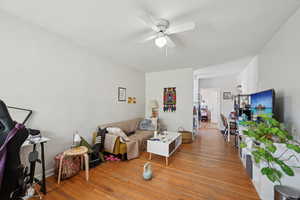 Living room featuring ceiling fan and wood finished floors