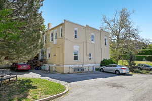 View of property exterior featuring uncovered parking and a chimney