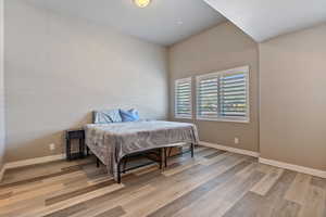 Bedroom featuring wood finished floors and baseboards