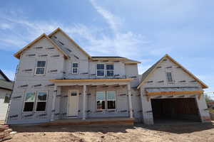 Property under construction featuring a porch and a 4 car tandem garage