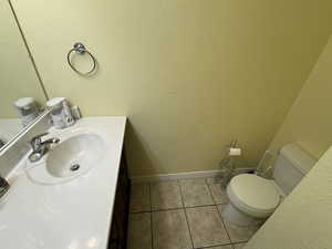 Bathroom with a textured wall, vanity, and light tile patterned floors