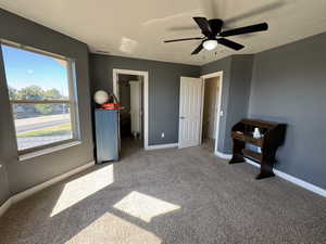 Unfurnished bedroom with carpet, a textured ceiling, and ceiling fan