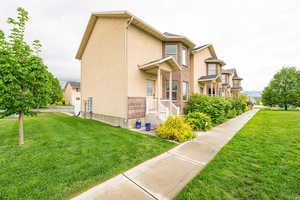 View of home's exterior with a lawn and stucco siding