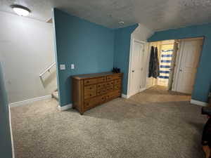 Carpeted bedroom with a textured ceiling and a closet