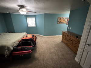 Bedroom featuring carpet, ceiling fan, and a textured ceiling