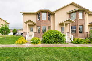 Traditional home featuring a front lawn and stucco siding