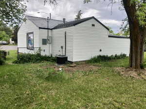View of home's exterior with metal roof, a yard, and cooling unit