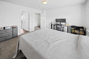 Bedroom with carpet floors, connected bathroom, and baseboards