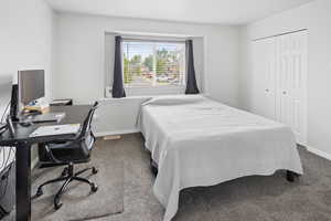 Carpeted bedroom featuring a closet and baseboards