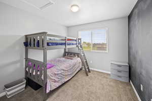 Carpeted bedroom featuring baseboards and attic access