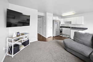Living room with baseboards and dark carpet