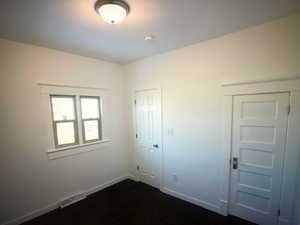 Unit A bedroom 2 with dark wood-style flooring and baseboards