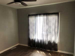 Unit B living room with dark wood finished floors, baseboards, and a ceiling fan