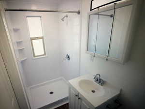 Unit B Full bathroom with vanity and a stall shower