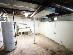 Unfinished basement with water heater and a sink