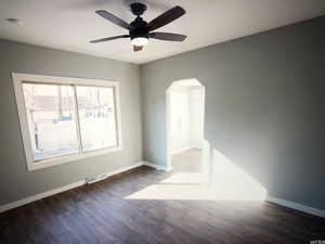 Unit B living room with arched walkways, baseboards, wood finished floors, and a ceiling fan