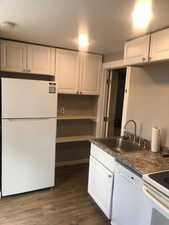 Unit B, Kitchen featuring white appliances, a sink, white cabinets, and dark wood finished floors