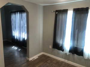 Unit B Dinning Area, dark wood-style flooring, baseboards, healthy amount of natural light, and arched walkways