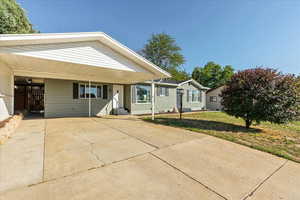 View of front facade featuring a front lawn and a carport