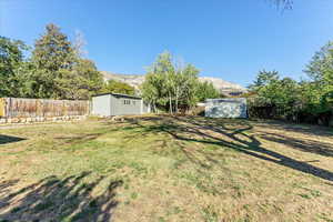 View of yard featuring an outbuilding, a shed, and a mountain view