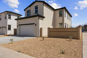 Mediterranean / spanish-style house with an attached garage, stucco siding, and fence