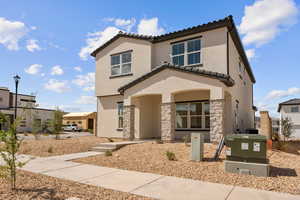 View of front of house featuring stone siding, a tile roof, stucco siding, and a residential view