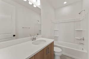 Bathroom featuring toilet, bathing tub / shower combination, vanity, tile patterned floors, and recessed lighting