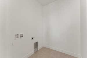 Clothes washing area featuring electric dryer hookup, hookup for a washing machine, baseboards, and light tile patterned floors