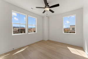 Unfurnished room featuring baseboards, light wood finished floors, and ceiling fan