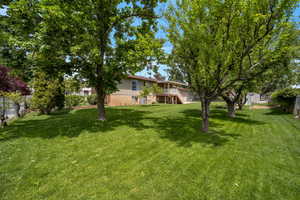View of yard featuring stairs, a wooden deck, and central AC unit