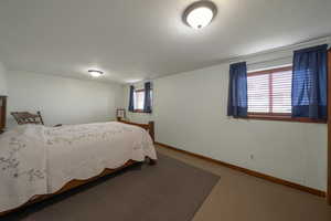 Bedroom with baseboards and a textured ceiling