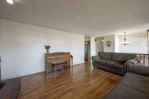 Living room featuring a chandelier, wood finished floors, and baseboards