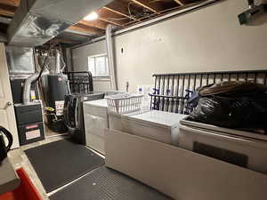 Laundry room featuring separate washer and dryer and water heater