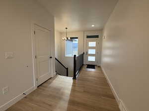 Entryway featuring a chandelier, hardwood / wood-style floors, baseboards, and recessed lighting