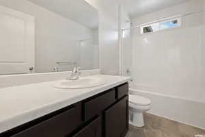 Bathroom featuring toilet, vanity, and washtub / shower combination