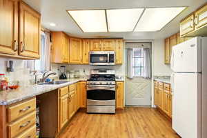 Kitchen featuring stainless steel appliances, a sink, light wood-style flooring, healthy amount of natural light, and recessed lighting