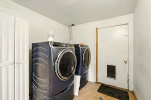 Washroom featuring independent washer and dryer and tile patterned flooring