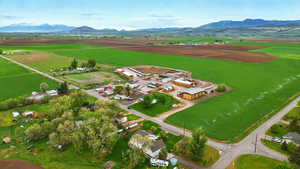 Aerial view of property and surrounding area featuring rural landscape, a mountainous background, and extensive farmland