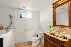 Bathroom with toilet, a bathtub, and vanity