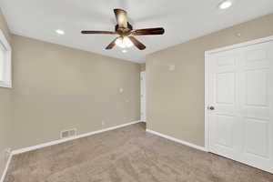 Carpeted empty room featuring a ceiling fan, baseboards, and recessed lighting