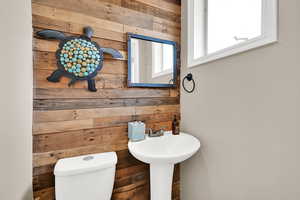 Half bath with wooden walls and toilet