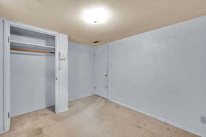 Unfurnished bedroom featuring a closet, baseboards, and tile patterned floors