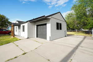 Garage with concrete driveway and fence